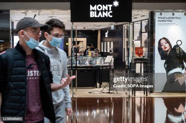 Shoppers walk past the German manufacturer of luxury writing instruments, watches, jewelry, Montblanc store in Hong Kong.