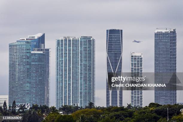 Plane flies over Miami residential towers in Miami, Florida, on January 20, 2022. - The increase in real estate prices in South Florida is one of the...