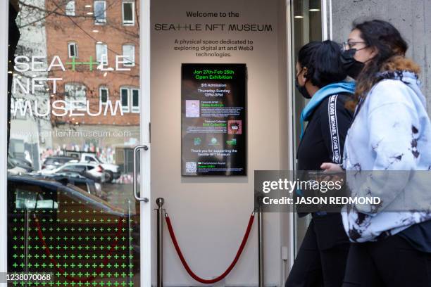 Pedestrians walk past the entrance of the Seattle NFT Museum during its opening weekend in Seattle, Washington on January 29, 2022. - Using the...