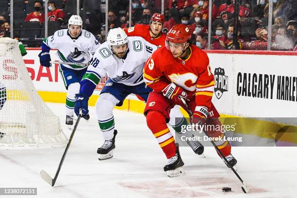 Johnny Gaudreau of the Calgary Flames carries the puck against Jason Dickinson of the Vancouver Canucks during an NHL game at Scotiabank Saddledome...