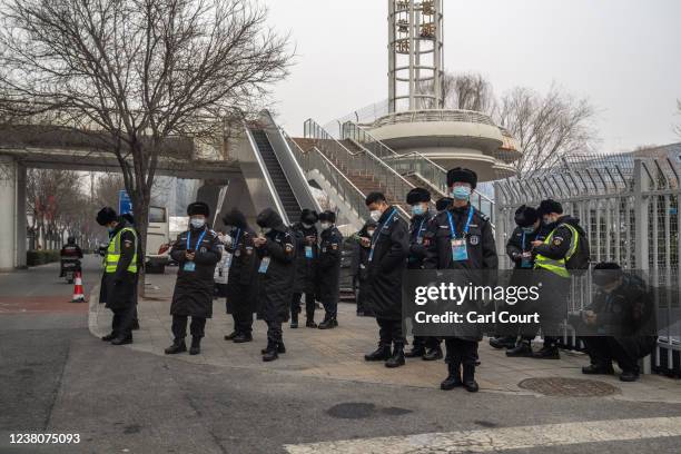 Security officials are pictured through the window of a taxi operating within the closed loop system as they gather near the National Indoor Stadium...