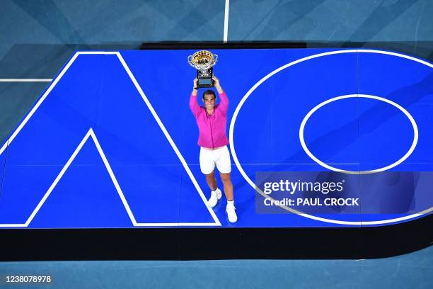 Spain's Rafael Nadal poses with the trophy after winning against Russia's Daniil Medvedev in their men's singles final match on day fourteen of the...