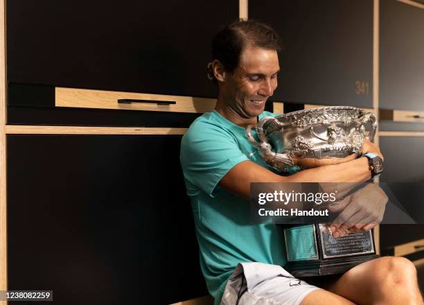 In this handout photo provided by Tennis Australia, Rafael Nadal poses with the Australian Open men's singles final trophy in the locker room...