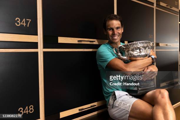 In this handout photo provided by Tennis Australia, Rafael Nadal poses with the Australian Open men's singles final trophy in the locker room...