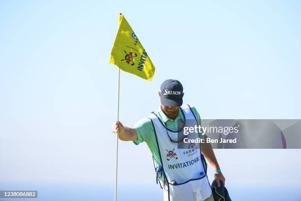 Caddie pulls the pin flag on the fifth green during the final round of the APGA Tour at Farmers Insurance Open at Torrey Pines South on January 30,...