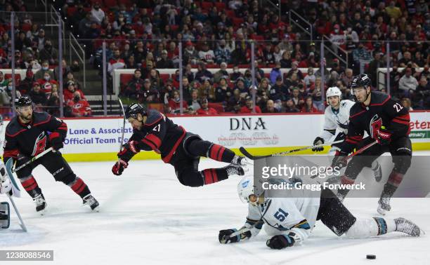 Nino Niederreiter of the Carolina Hurricanes gets tripped up and goes airborne by Radim Simek of the San Jose Sharks during an NHL game on January...