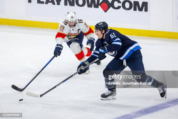 Mark Scheifele of the Winnipeg Jets plays the puck to avoid Aleksander Barkov of the Florida Panthers during third period action at Canada Life...