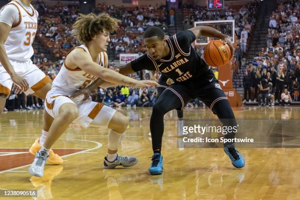 Oklahoma State Cowboys guard Bryce Thompson pushes off against Texas Longhorns guard Devin Askew during the first of the game between Texas Longhorns...