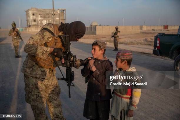 Two Afghan children talk to Taliban special forces on December 02 2021 in Kandahar, Afghanistan.