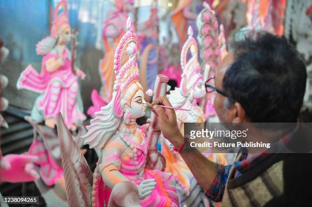 An artist paints a sculpture of the goddess Saraswati in his workshop during the Vasant Panchami, also called Saraswati Puja. It is a religious...