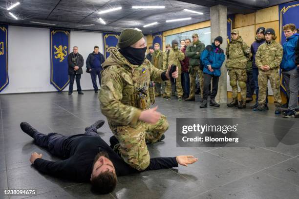 An instructor demonstrates how to stop bleeding with a tourniquet during an introductory level military and first aid training session for civilians...