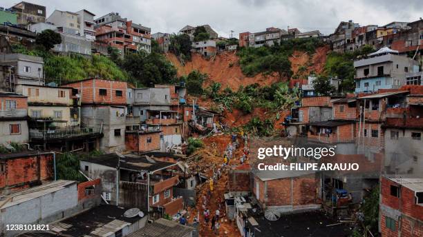 General view of citizens helping firefighters remove mud in search of victims after a landslide caused by heavy rains buried homes in Franco da...