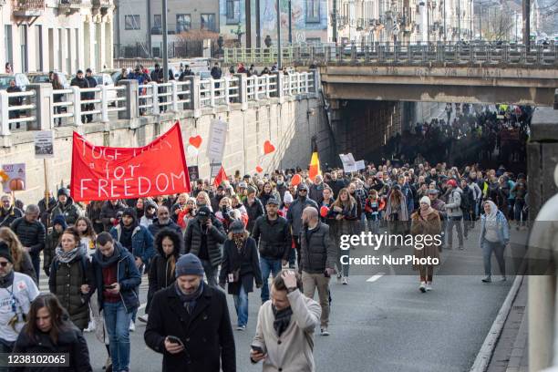 The crowd at the protest with various banners and flags. Protest against the government and COVID measures in the Belgian capital, Brussels. The...