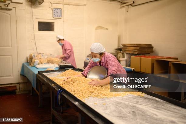 Members of staff at the traditional sweet manufacturer Edward Grays of Dudley, or better known locally as 'Teddy Grays', gather freshly-made Grays...