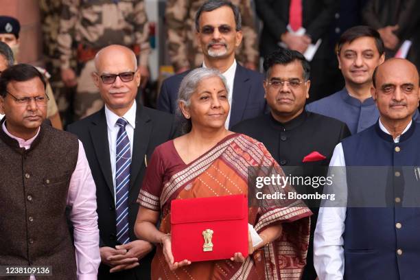 Nirmala Sitharaman, India's finance minister, center, and other members of the finance ministry pose for photographs as they leave the North Block of...