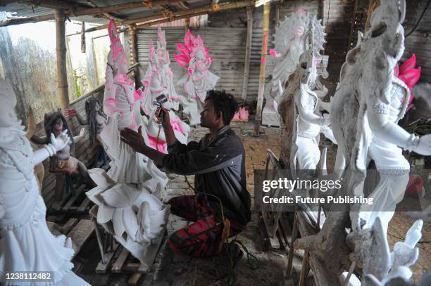 An artist paints a sculpture of the goddess Saraswati during the preparations for the Vasant Panchami Festival, also called Saraswati Puja, in honor...