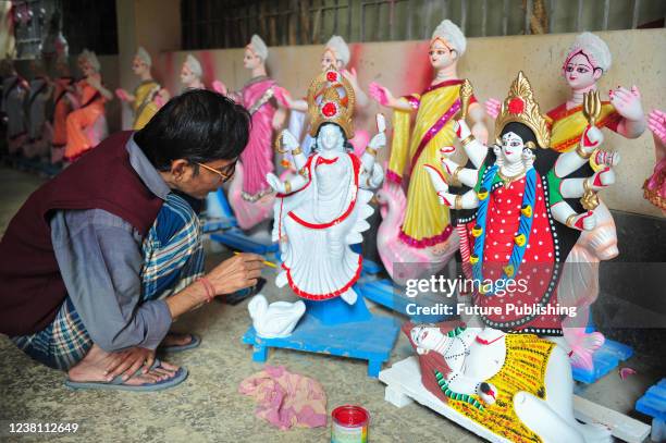 An artist paints a sculpture of the goddess Saraswati during the preparations for the Vasant Panchami Festival, also called Saraswati Puja, in honor...