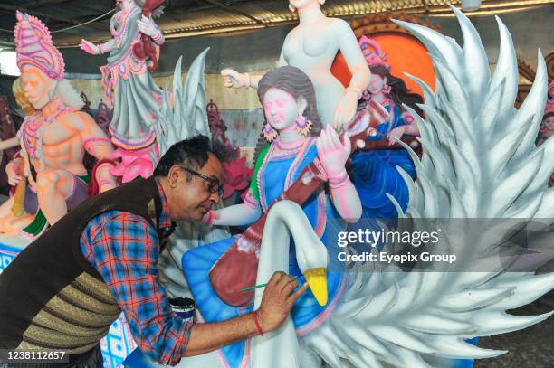 An artist paints a sculpture of the goddess Saraswati during the preparations for the Vasant Panchami Festival, also called Saraswati Puja, in honor...