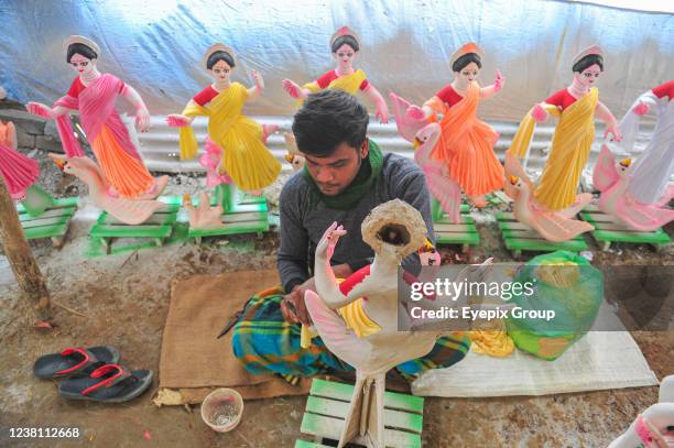 An artist paints a sculpture of the goddess Saraswati during the preparations for the Vasant Panchami Festival, also called Saraswati Puja, in honor...