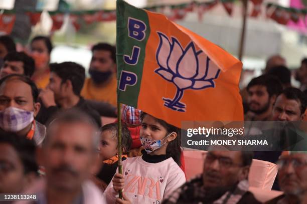 Young supporter of Bharatiya Janata Party waves a party flag as she attends along with others a rally addressed by Chief Minister of Uttar Pradesh,...