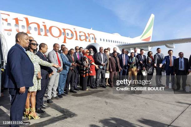Ethiopian Airlines employees pose for a group photo in front of a Boing 737 MAX on the tarmac of the Bole International Airport in Addis Ababa on...