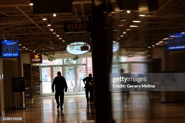 Man makes his way down a near empty hallway in the Student Union after UCLA canceled in-person classes Tuesday after a former lecturer and...