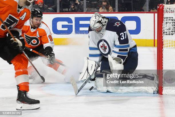 Connor Hellebuyck of the Winnipeg Jets makes a pad save as Ivan Provorov of the Philadelphia Flyers anticipates a rebound at the Wells Fargo Center...