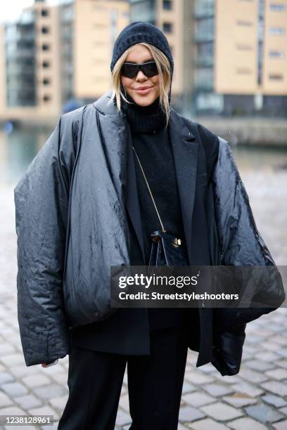 Influencer Gigi Vives wearing a black jacket by Yeezy x Gap, a black blazer by Mango, a black hoodie by Weekday, black pants by na-kd, black boots by...