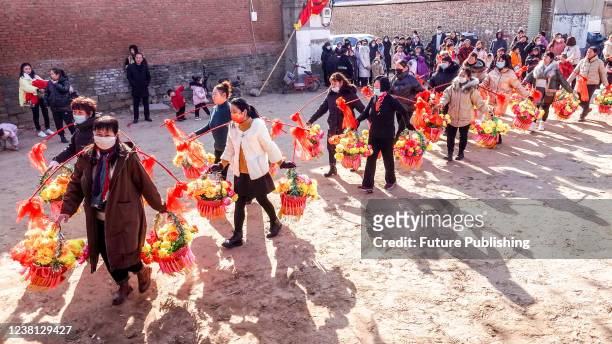 Villagers parade with flowery baskets in a traditional gatheirng to celebrate the lunar New Year in Huaxian county in central Chinas Henan province...