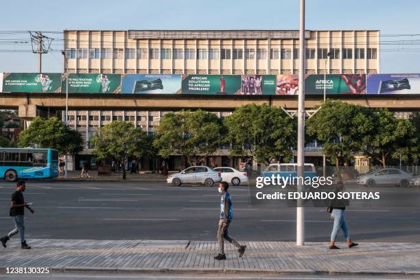 People walk in a street as in the background can be seen a banners set as part of the preparations in the city for hosting the 35th ordinary summit...