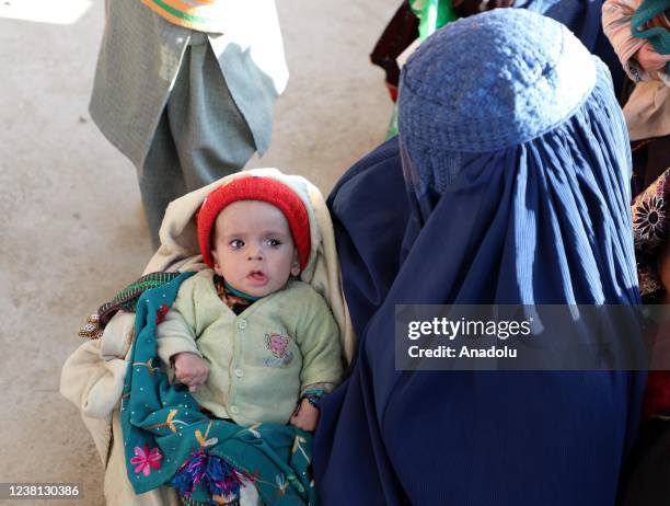 Afghan children are seen with their mothers in Kabul, Afghanistan on January 16, 2022. In Afghanistan, children cannot stand on their feet despite...