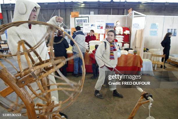 Une personne regarde un tisseur de laine déguisé en mouton, le 26 février 2005 au salon Primevère, vaste supermarché d'idées et de produits bios et...