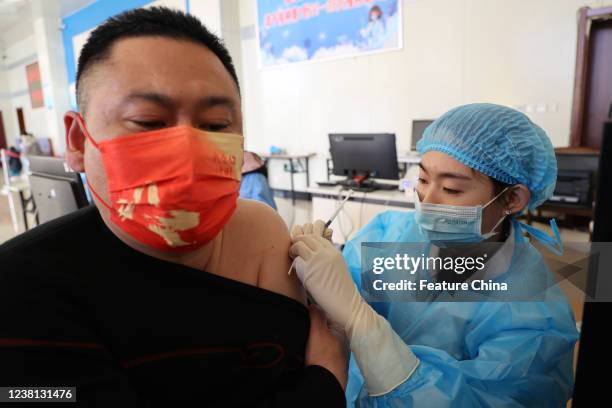 Man takes a jab of the Covid-19 vaccine at a community inoculation site in Binzhou city in east Chinas Shandong province Tuesday, Feb. 01 the lunar...