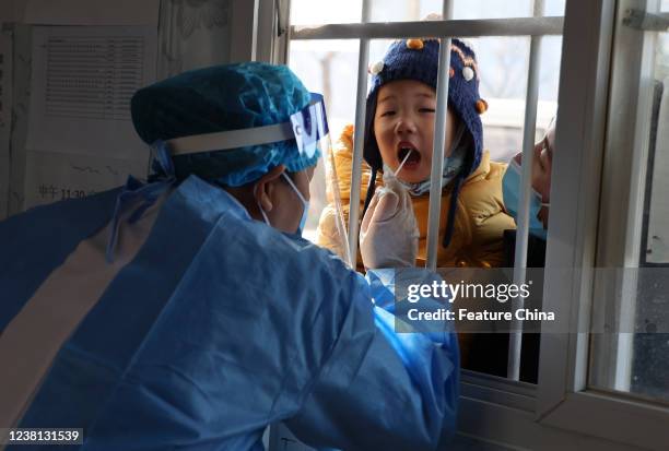 Medical worker takes throat swabs on residents for the Covid-19 test at a community test site in Binzhou city in east Chinas Shandong province...