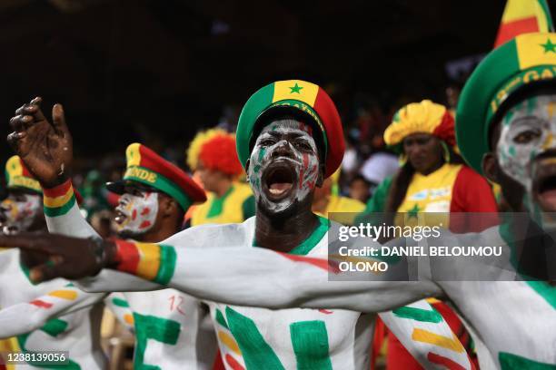 Senegal's football fans sporting fancy hats with the colours of their national flags react before the Africa Cup of Nations 2021 semi final football...