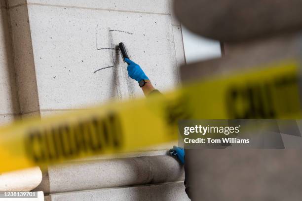 Worker uses a wire brush to clean off swastikas that were drawn on the exterior of Union Station in Washington, D.C., on Wednesday, February 2, 2022....