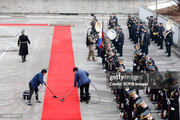 The cleaning service workers vacuum the red carpet before the Slovenian Minister of Defence Matej Tonin receives the UK Secretary of State for...