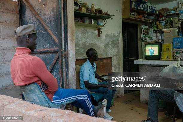 Senegal supporters gather in a small shop in Dakar on February 2, 2022 to watch the Africa Cup of Nations 2021 semi-final football match between...