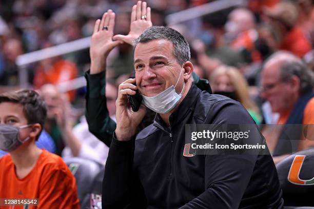 Miamis new head football coach, Mario Cristobal, takes a phone call while sitting court-side in the second half as the University of Miami Hurricanes...