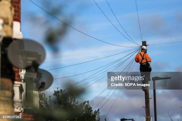 Network engineer from Openreach, a unit of BT Group Plc, carries out maintenance work at the top of a telegraph pole.
