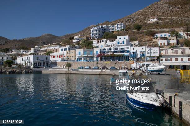 Scene of the harbor of the island with some small boats moored. Livadia, the port and main village of Tilos island with the whitewashed traditional...