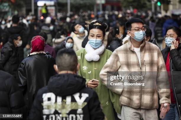 Pedestrians wearing protective masks make their way along Nanjing Road in Shanghai, China, on Wednesday, Feb. 2, 2022. China needs to step up...