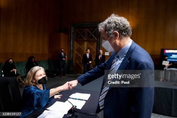 Chairman Sen. Sherrod Brown, D-Ohio, fist bumps Sarah Bloom Raskin, nominee to be vice chairman for supervision and a member of the Federal Reserve...