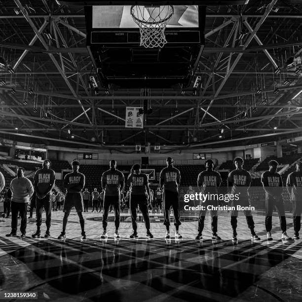 Raptors 905 players and coaches stand solemnly during the singing of the American and Canadian national anthems before an NBA G League game against...