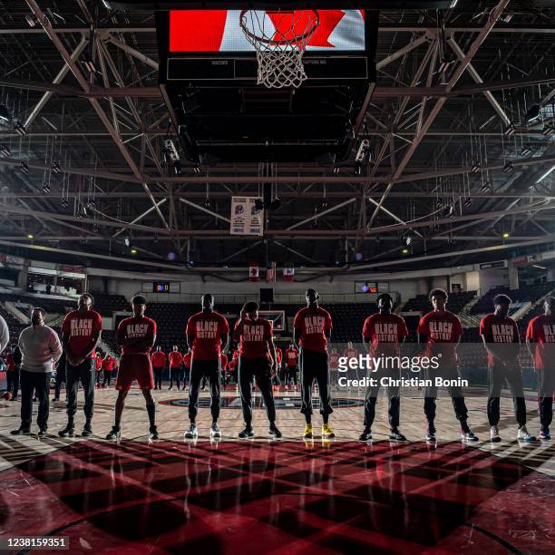 Raptors 905 players and coaches stand solemnly during the singing of the American and Canadian national anthems before an NBA G League game against...