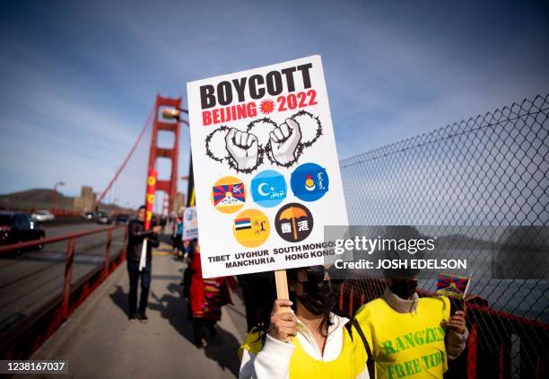 Protester holds up a "Boycott Beijing 2022" sign after marching across the Golden Gate Bridge during a demonstration against the 2022 Beijing winter...