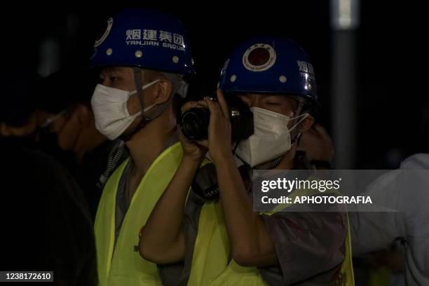 Chinese construction worker takes images during the National Library's foundation stone ceremony on February 3, 2022 in San Salvador, El Salvador.