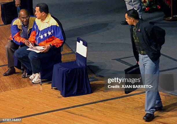 Security agent watches over Venezuelan President Hugo Chavez 29 January during a meeting with Venezuelan athletes in Caracas. Vice foreign ministers...