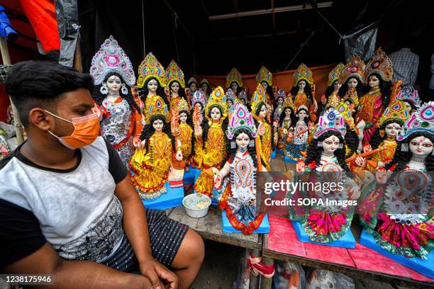 An artist stares at his creations displayed for sale before Saraswati Puja Festival at Kumartuli. Basant Panchami or Vasant Panchami is a Hindu...