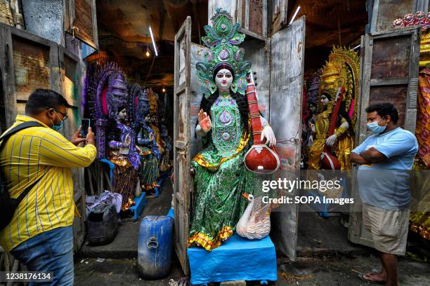 Man takes pictures of the Devi Saraswati idol during the preparations for the upcoming Basant Panchami festival. Basant Panchami or Vasant Panchami...